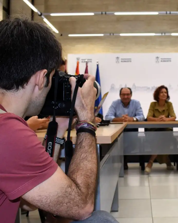 Fotógrafo trabajando en una cobertura informativa durante una comparecencia institucional